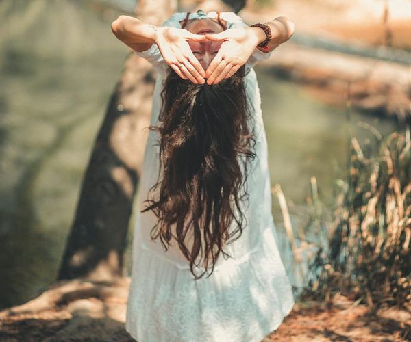 Person meditating peacefully in a calm natural environment.